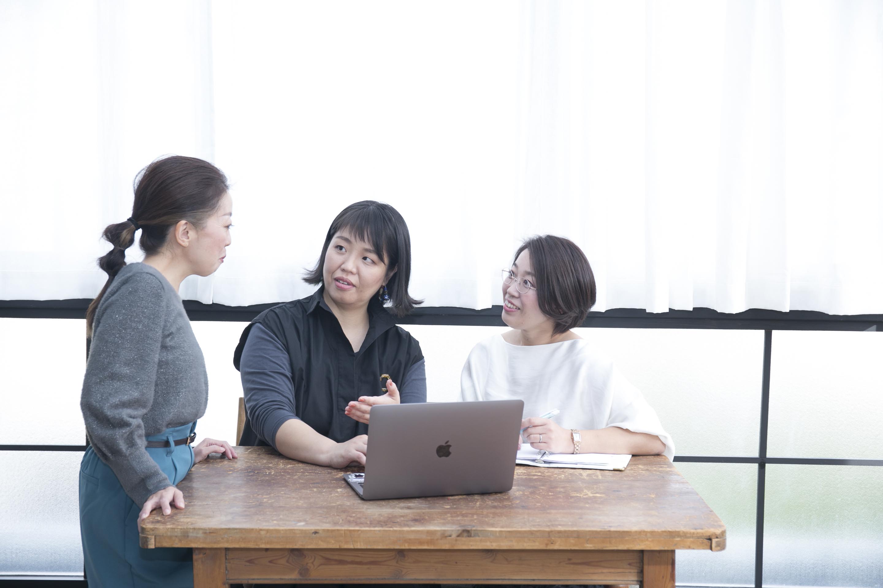 講師と受講生が一緒に笑いながら打ち合わせしている様子